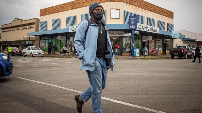 Un hombre camina con mascarilla por Johannesburgo.
