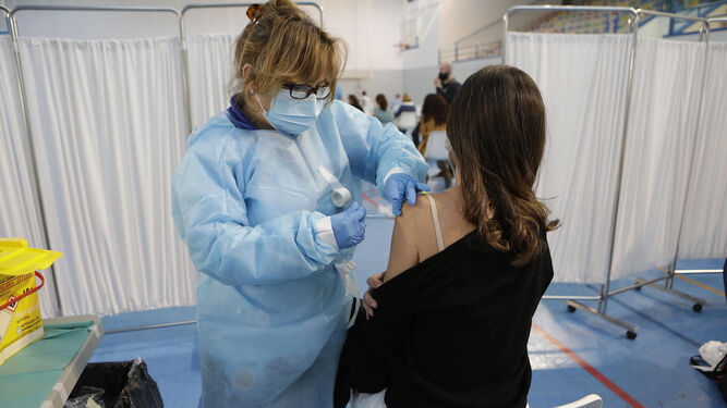 Una docente se vacuna  en las instalaciones deportivas de la US en Los Bermejales el pasado mes de febrero.