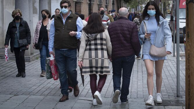 Un grupo de gente con mascarilla pasea por la calle