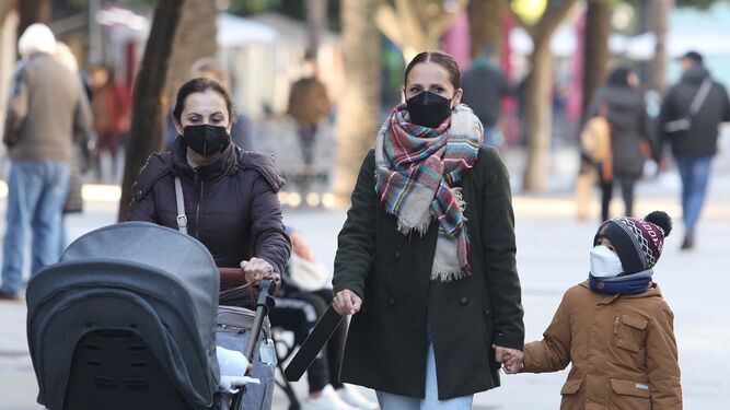 Dos mujeres pasean con niños, todos con la mascarilla puesta, por el centro de Jerez.