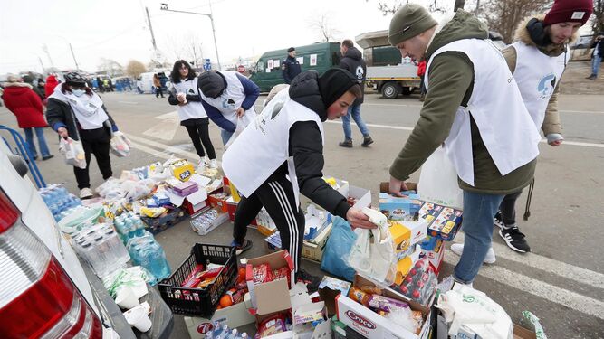 Un grupo de personas reparte alimentos para los refugiados que salen de Ucrania