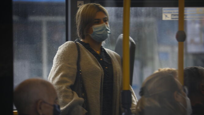 Una mujer protegida con su mascarilla en un autobús.