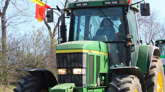 Agricultora conduce un tractor por su explotación.