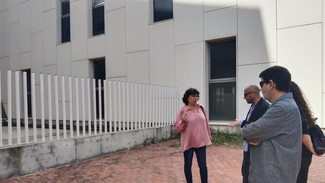 Los responsables de IU junto al edificio del fracasado centro de congresos del PTA de Jerez.