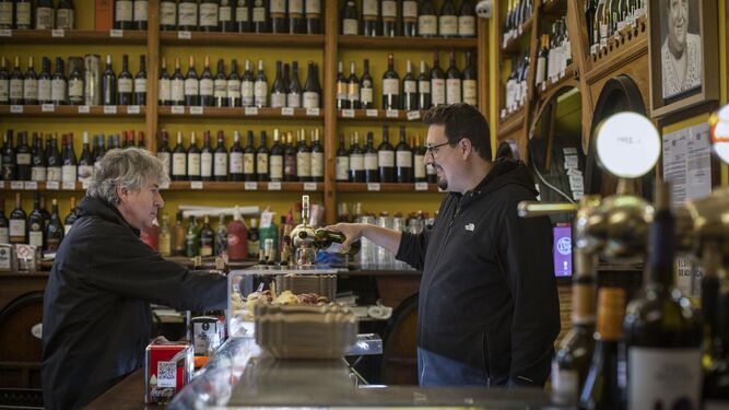 Un camarero sirve una consumición a un cliente en una bodega de Zaragoza.