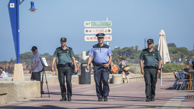 La patrulla mixta de la Guardia Civil y la Policía alemana recorriendo el Paseo Marítimo de La Barrosa.