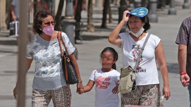 Dos mujeres caminan con una niña por una calle del centro de Jerez
