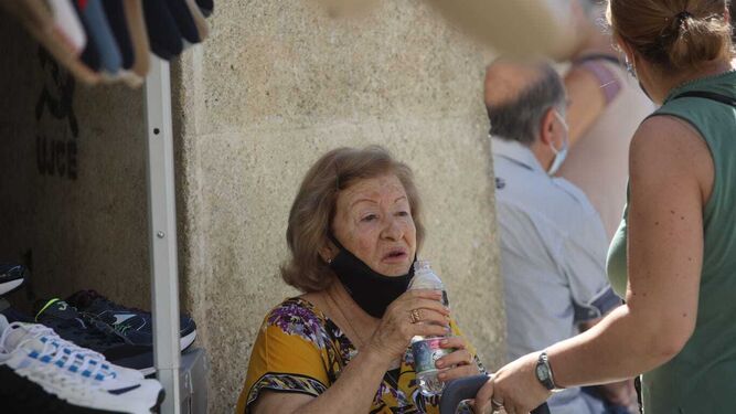 Una mujer se refresca con agua cerca de la plaza de abastos de Jerez