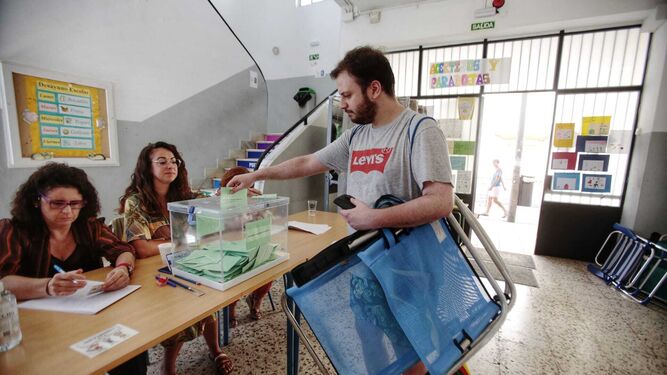 Un ciudadano deposita su voto en las urnas este 19 de junio tras pasar por las playas gaditanas.
