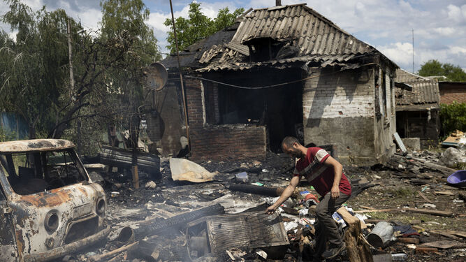 Un ucraniano intenta recuperar algunos objetos de su casa, incendiada tras el ataque de misiles rusos.