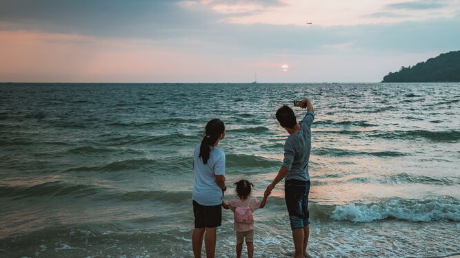 Una familia se hace un selfie junto al mar