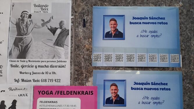 Carteles reales de Joaquín pidiendo trabajo junto a otros anuncios en una calle de Vitoria