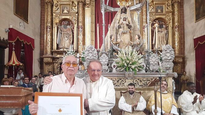 El padre Felipe Ortuno entrega un diploma a Pepe Carretero.