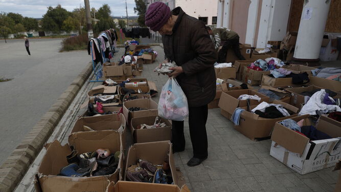 Una ucraniana revisa unos zapatos de segunda mano donados para la gente necesitada en Izium.