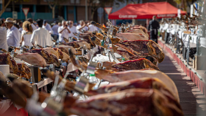 Hilera de patas de jamón, listas para cortar en la Feria Solidaria de Cortadores celebrada en San Fernando.