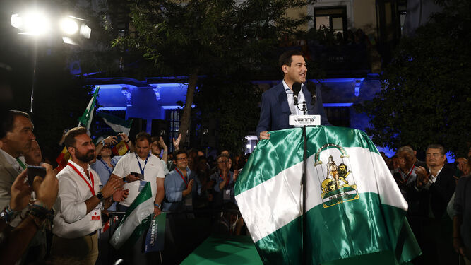Juanma Moreno con una bandera de Andalucía el día de su victoria electoral.