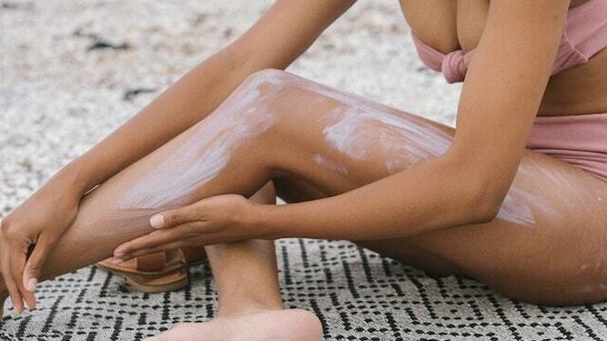 Una mujer se coloca crema anticelulítica en su pierna