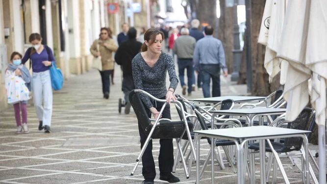 Una camarera monta la terraza de un bar en el centro de Jerez.