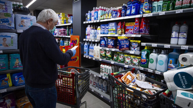 Un hombre en un supermercado con la lista de la compra