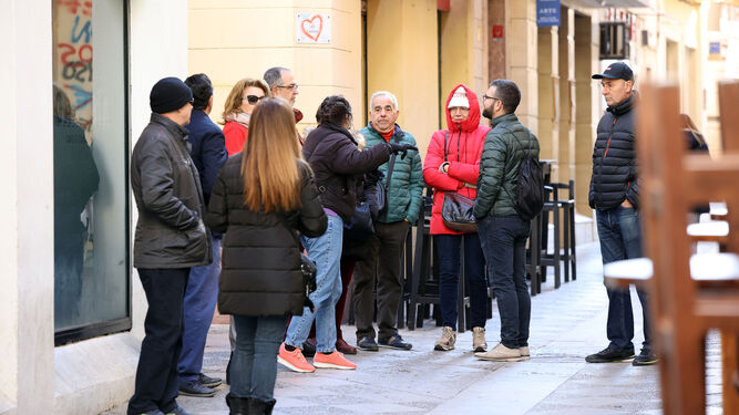 Un grupo de turistas atendiendo las explicaciones de una guía en una céntrica calle de Jerez.