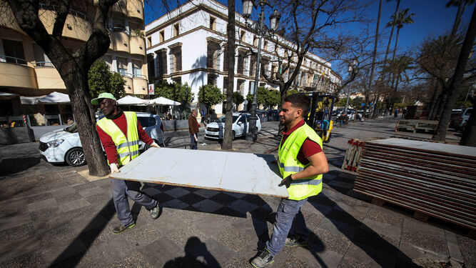 Dos operarios instalando los palcos de la carrera oficial en la Alameda Cristina.