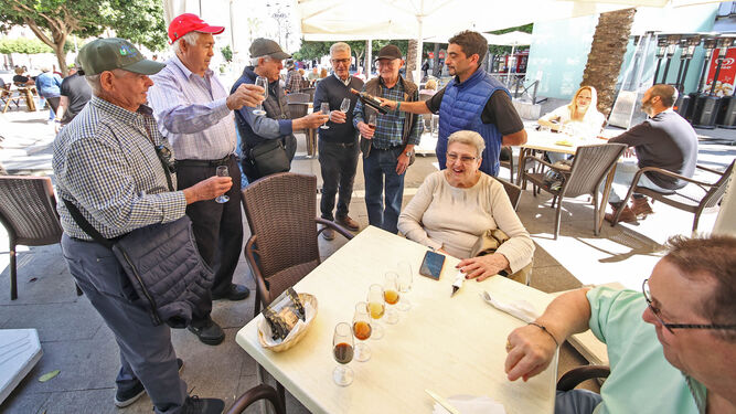 Un camarero sirva unas copas de Jerez a un grupo de clientes en un bar de la plaza del Arenal.