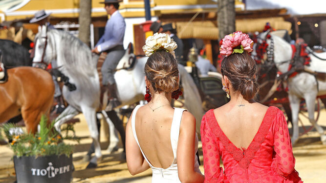 Dos mujeres de espaldas en primer plano en la Feria del Caballo 2019.