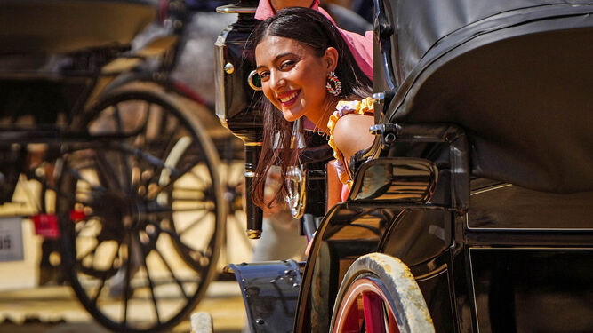 Una chica sonríe desde un coche de caballos en la Feria de Jerez