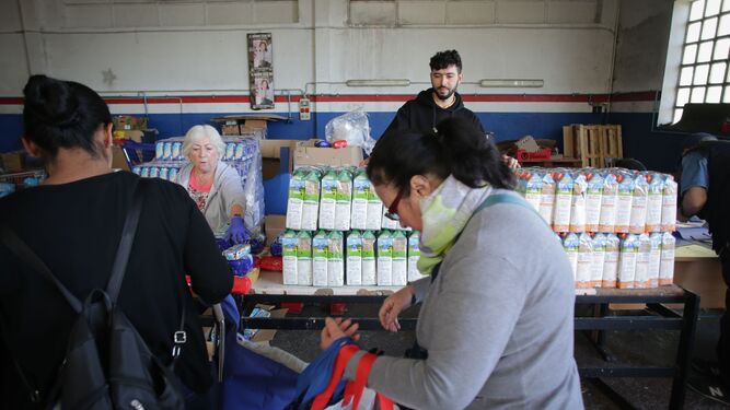 Voluntarios atienden a las personas que van a buscar comida al almacén del Banco de Alimentos de Lugo.