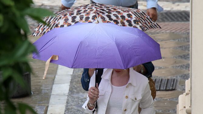 Dos mujeres caminando con paraguas en el centro de Jerez