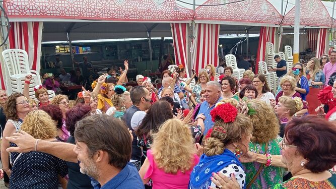 Un grupo  muy animado de personas bailando en el Real de la Feria de la Manzanilla de Sanlúcar.