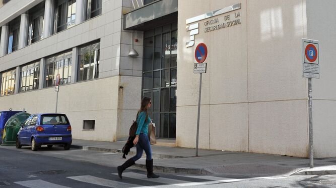 Una mujer pasa por delante de una oficina de la Seguridad Social en Sevilla.