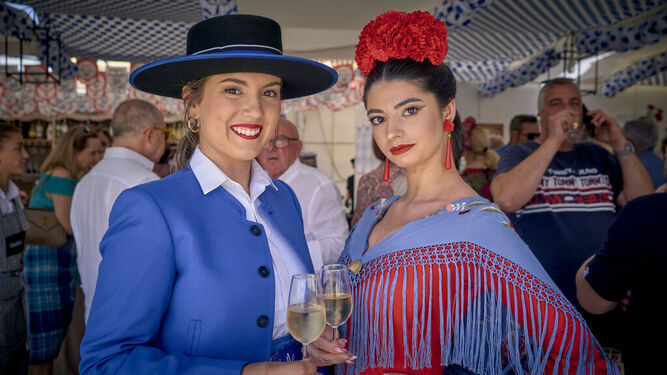Dos mujeres posan con una copa de manzanilla en la Feria de Sanlúcar.