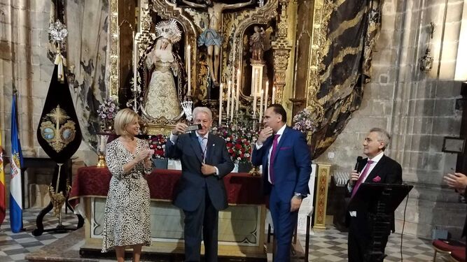 Andrés Luis Cañadas alzando su distinción de ‘Potencia para un Cofrade Ejemplar’ junto a la alcaldesa y hermano mayor de la Viga.