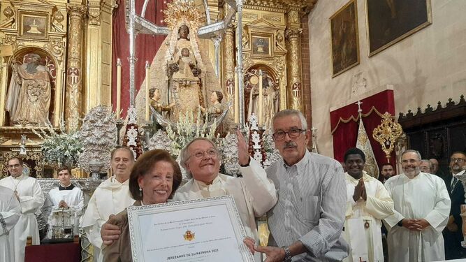 El matrimonio Suárez Jaime junto al padre Felipe Ortuno en el momento de la entrega del diploma.