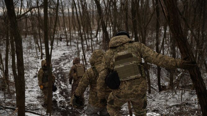 Soldados ucranianos regresan a sus posiciones tras completar una misión.