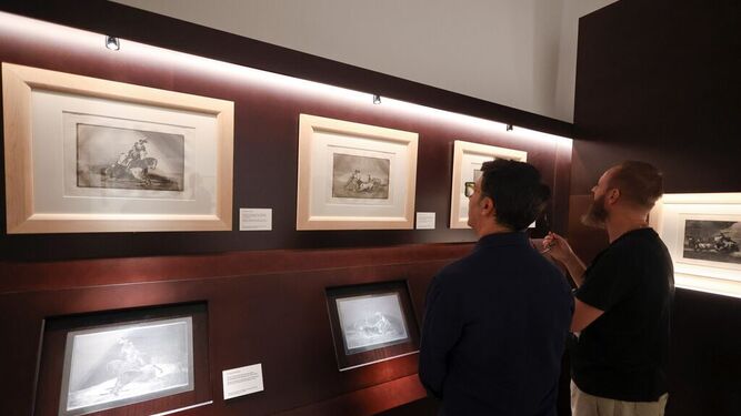 Dos asistentes observan algunas obras del ciclo ‘Leyendo imágenes: Goya, Picasso y la filosofía’ .