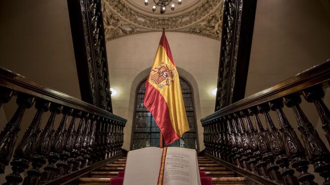 Un ejemplar de la Constitución, fotografiado junto a una bandera de España.