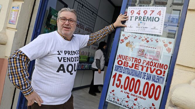 Uno de los responsables de la administración de loterías mostrando el número premiado.