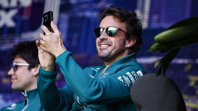 Fernando  Alonso  bromea con su móvil junto a Lance Stroll, su compañero en Aston  Martin.