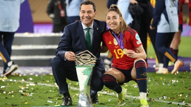 Juanma Moreno posa con la sevillana Olga Carmona y la copa de campeonas.