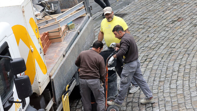 trabajadores de la construcción descargan material para una obra en el centro de Jerez.