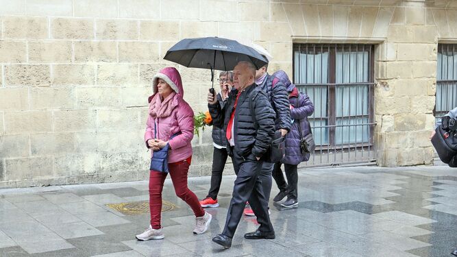 Varias personas caminando bajo la lluvia por la calle Consistorio de Jerez