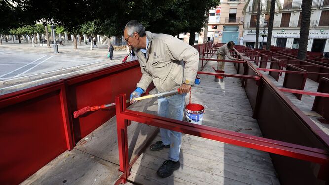 Un operario municipal, pintando los palcos de la Plaza del Arenal.