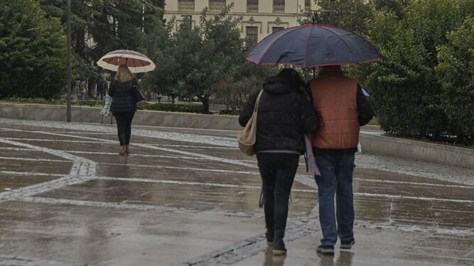 Personas paseando bajo la lluvia en Granada | Imagen de archivo