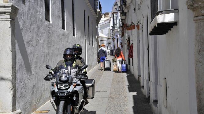 Varios turistasen moto  por una calle de Arcos